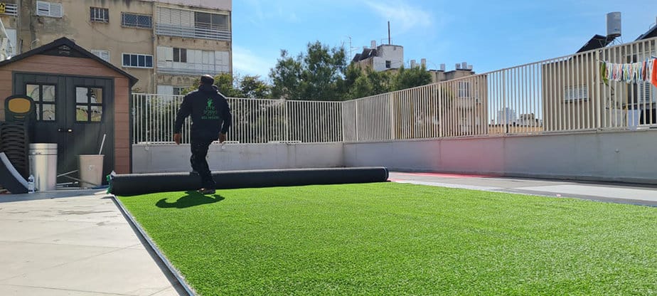 התקנת דשא סינטטי בחצר. צילום באדיבות שירת העשבים