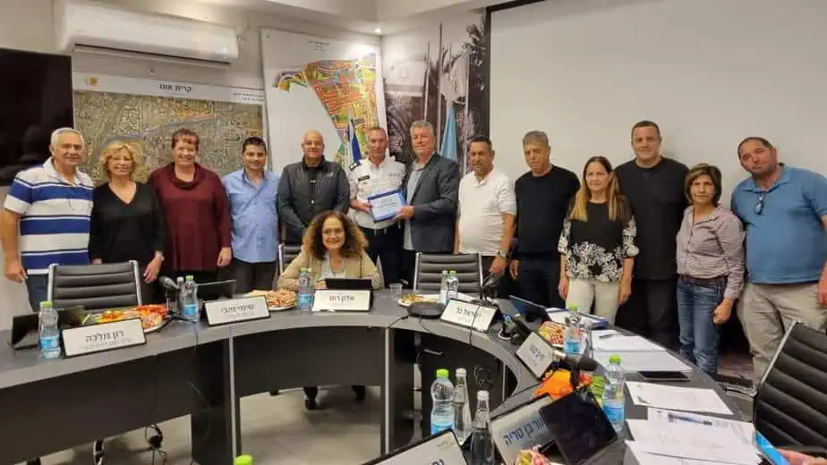 ישראל גל, ראש העיר קריית אונו, מעניק מגן הוקרה לניר שלהב (במדי מד"א) יחד עם חברי מועצת העיר, והוריו של ניר (משמאל). צילום עיריית קריית אונו
