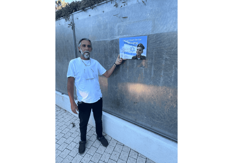 מושיקו אביה של שירת ים עמר ז"ל תולה תמונה לזכרה. צילום: באדיבות עיריית גני תקווה