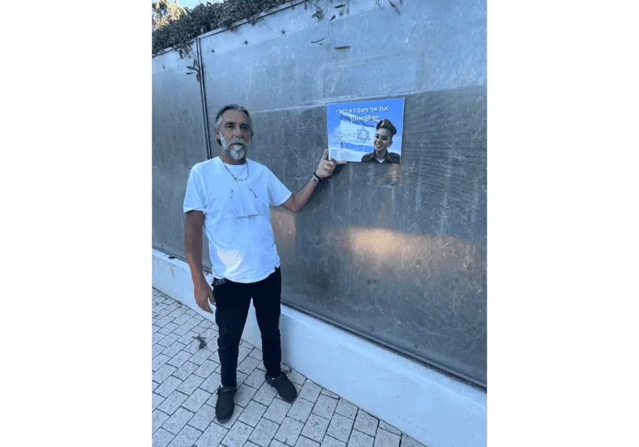 מושיקו אביה של שירת ים עמר ז"ל תולה תמונה לזכרה. צילום: באדיבות עיריית גני תקווה